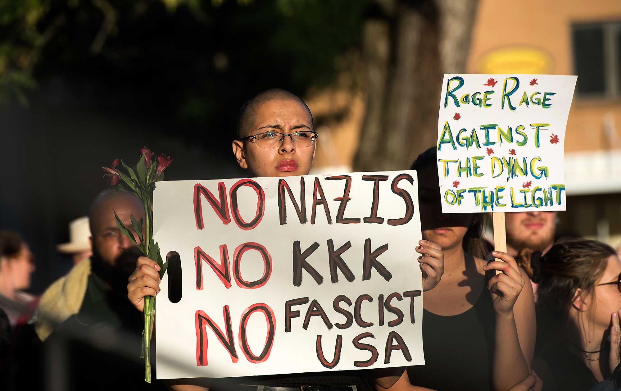 Brenda Diaz-Castro, holds a sign during a candlelight vigil on Sunday, Aug. 13, 2017, in Harrisonburg, Va. The vigil was held for the victims of the violence in Charlottesville, Va., on Saturday.