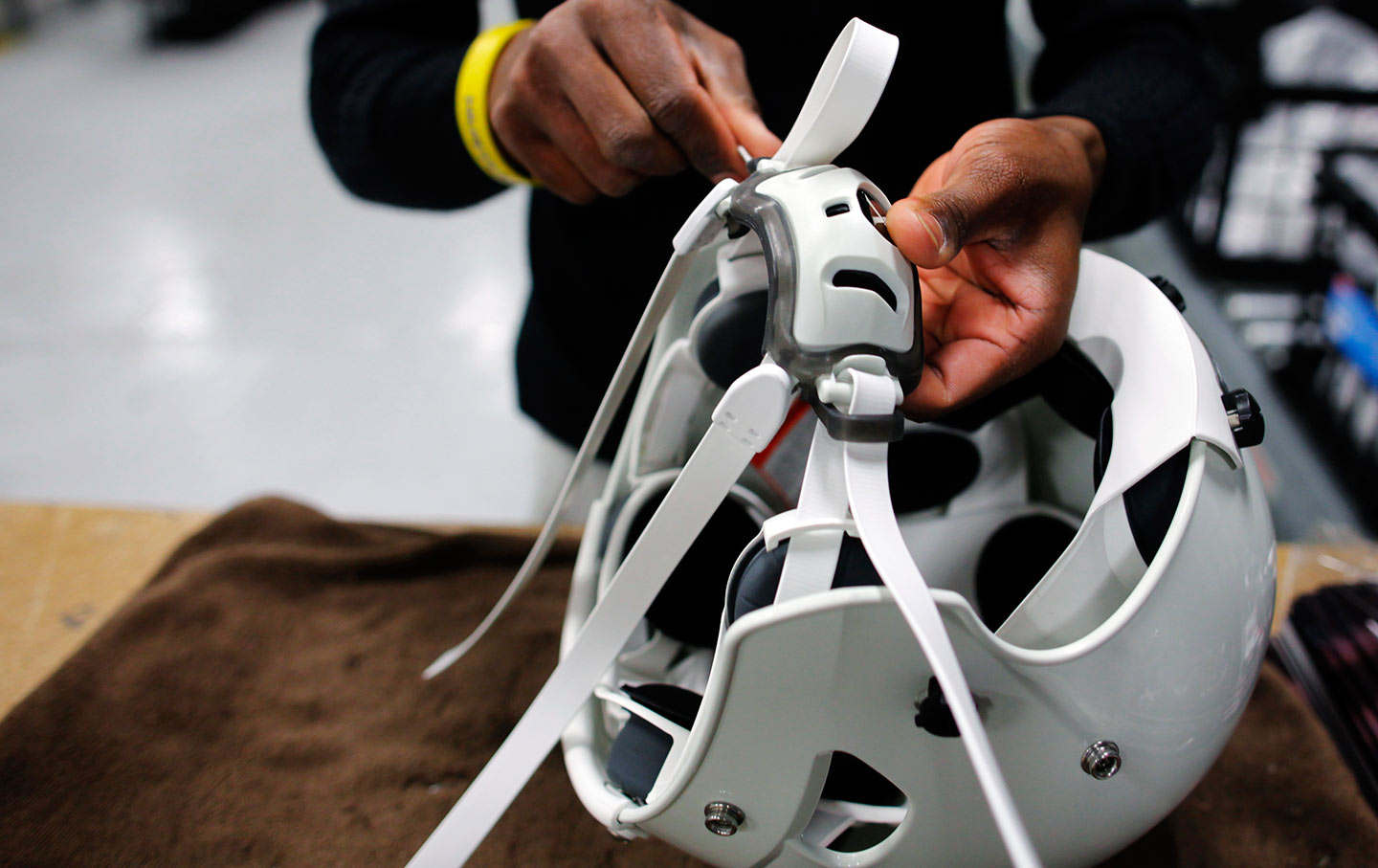 A worker assembles a football helmet in Lowell, Massachusetts.