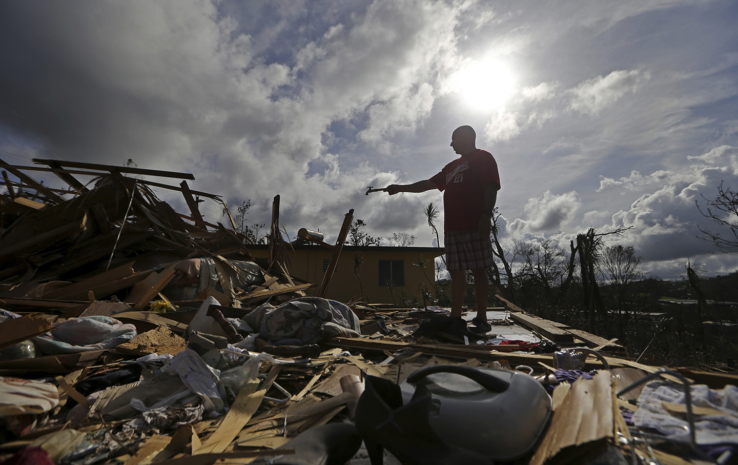 Jose Garcia Vicente holds a piece of plumbing he picked up, as he shows his destroyed home, in the aftermath of Hurricane Maria, in Aibonito, Puerto.