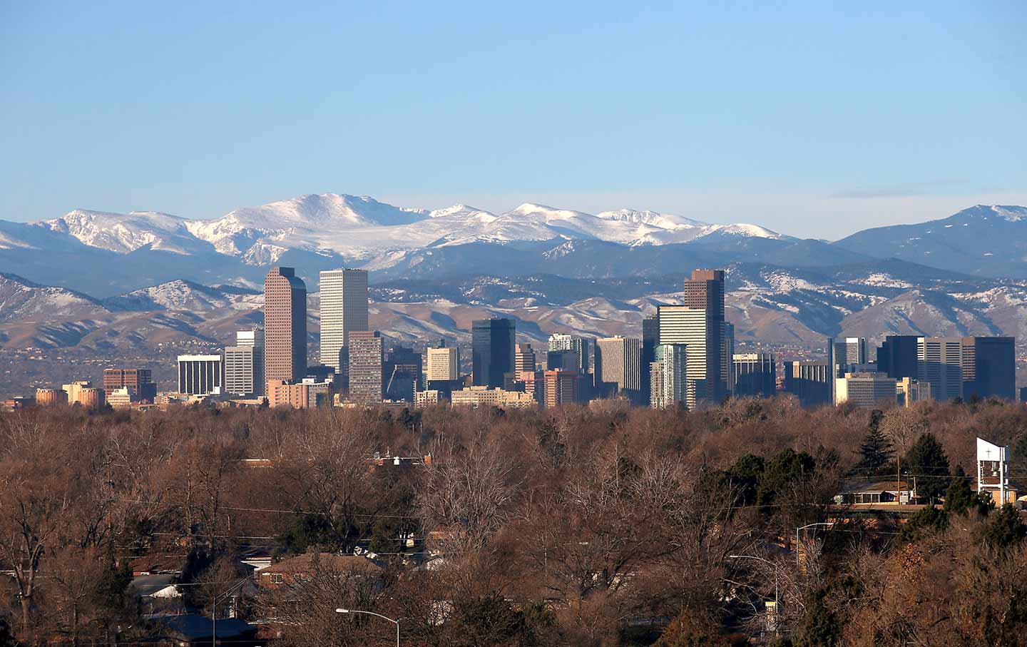 The city skyline of Denver, Colorado, with the Rocky Mountains in the dista...