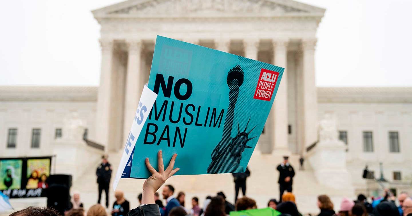 A person holds up a sign that reads 