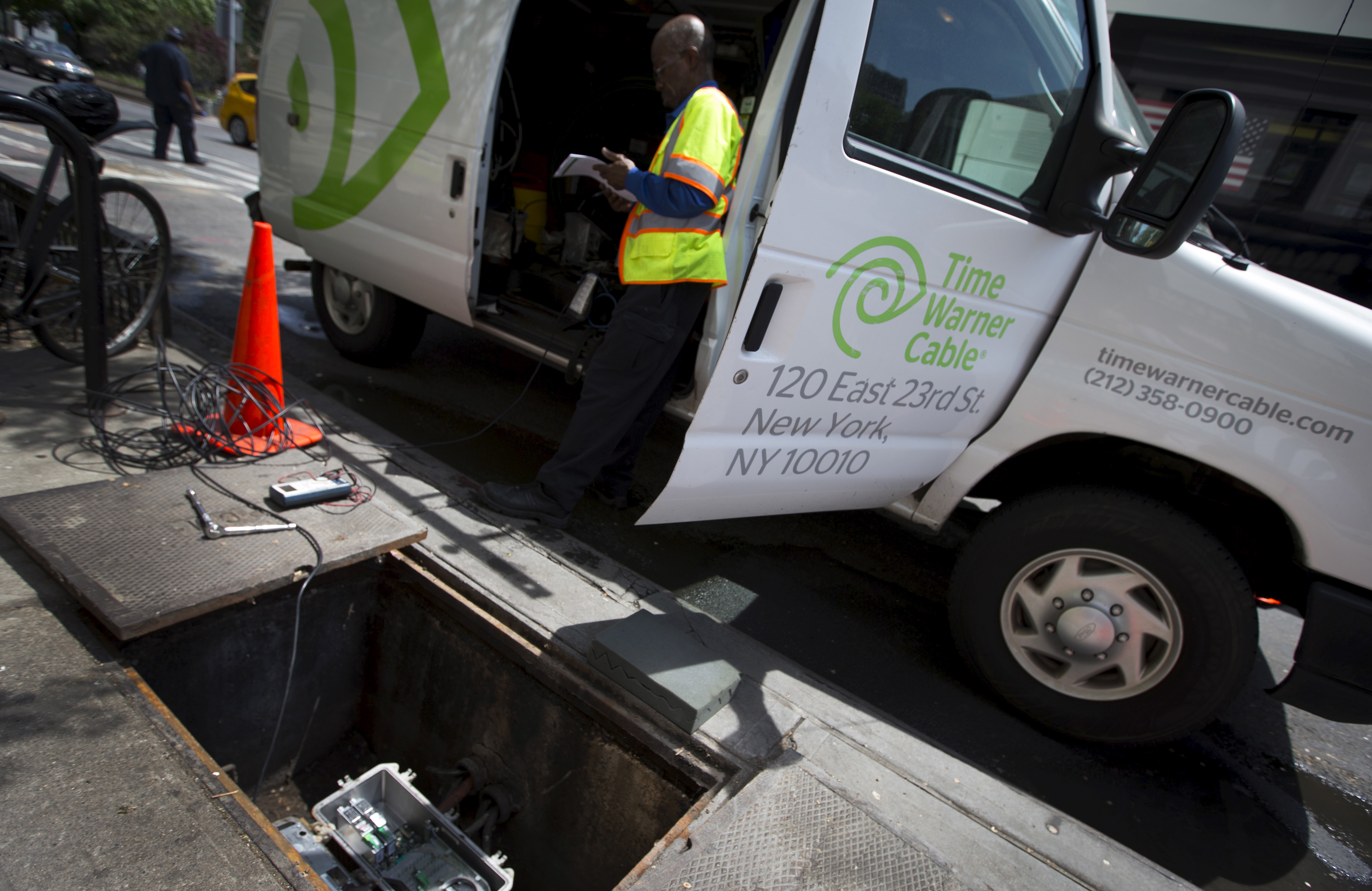 A Time Warner Cable service technician works on cable service from a van parked on the Upper West side of the Manhattan borough of New York City