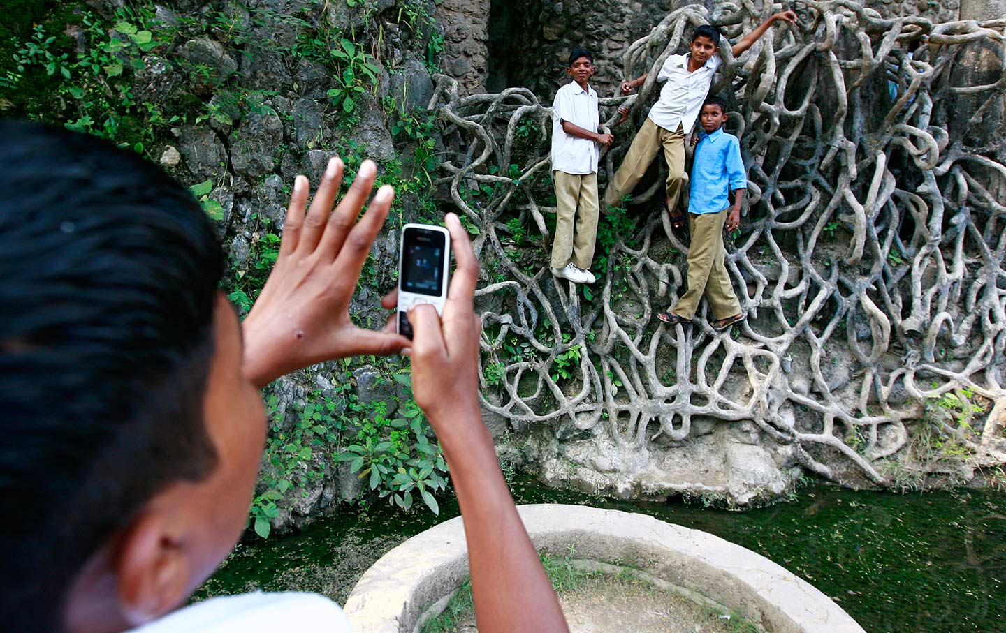 A schoolboy uses his cell phone to take a picture of classmates