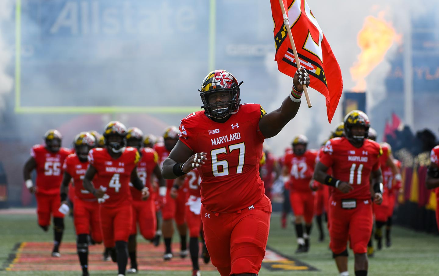 The Umd Football Team Comes Together To Kick A Booster Off A