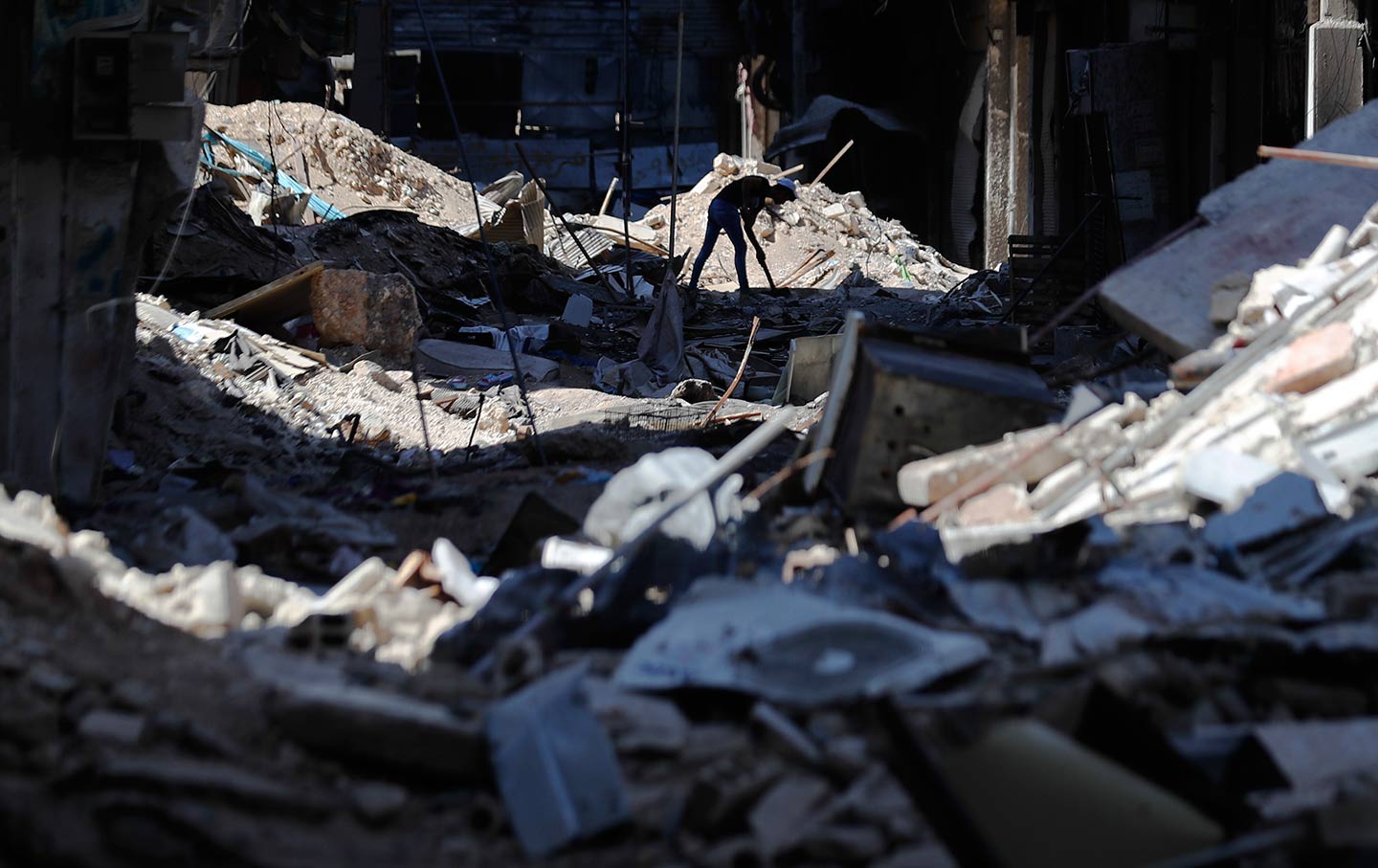 A young man removes rubble in Syria