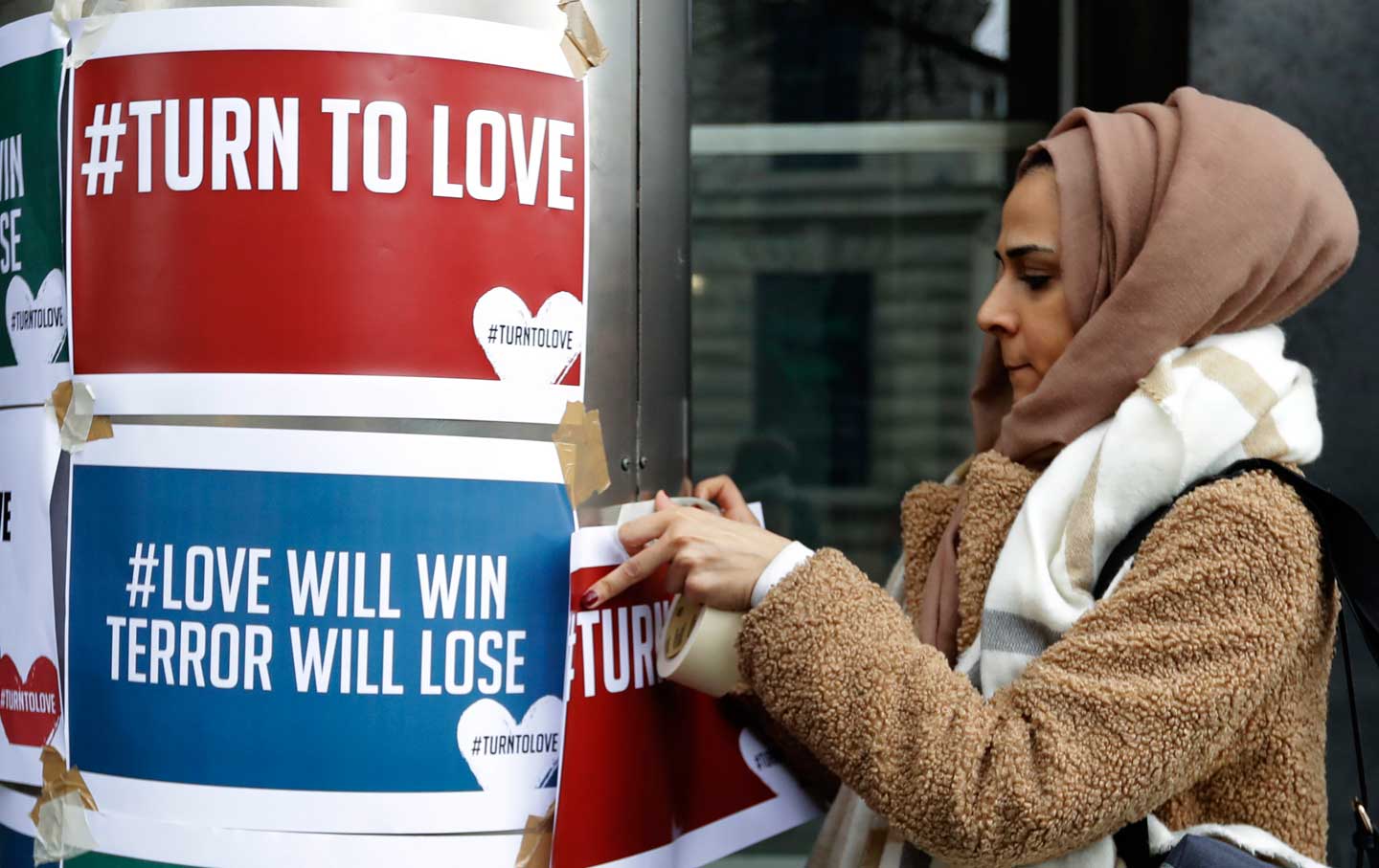 A demonstrator hangs banners from multi-faith group 'Turn to Love'