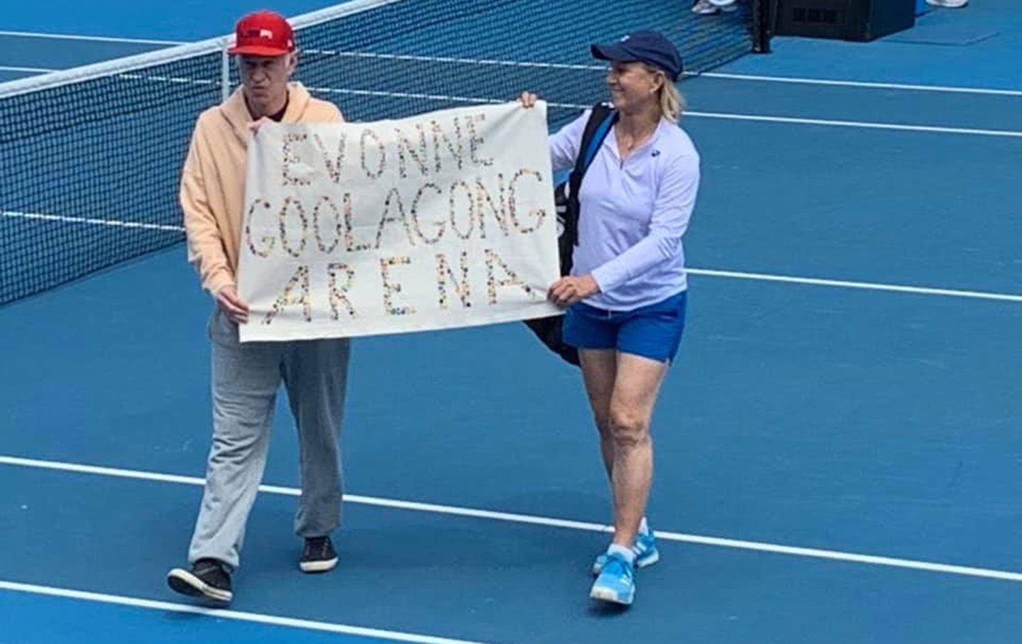 John McEnroe and Martina Navratilova walk onto the court at the Australian Open with a banner that reads 