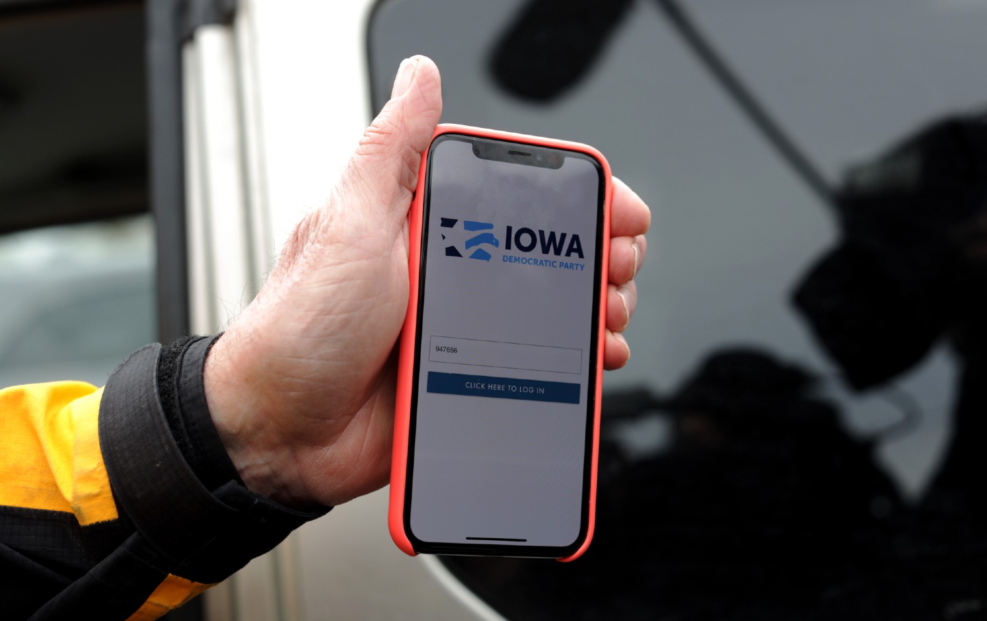 A precinct chair holds up his phone showing the Iowa caucus app