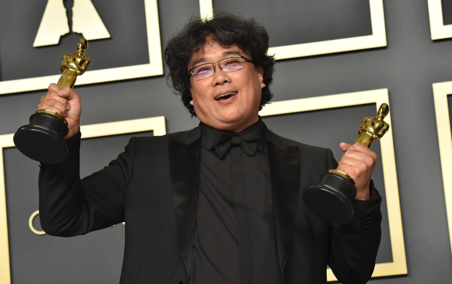 Bong Joon-ho holding two Oscars.
