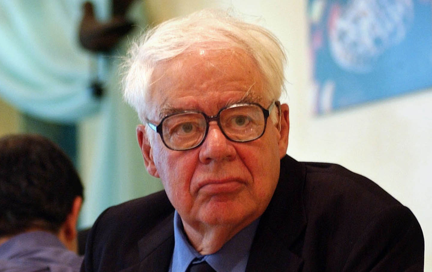 Richard Rorty waiting to speak, wearing glasses and a suit.