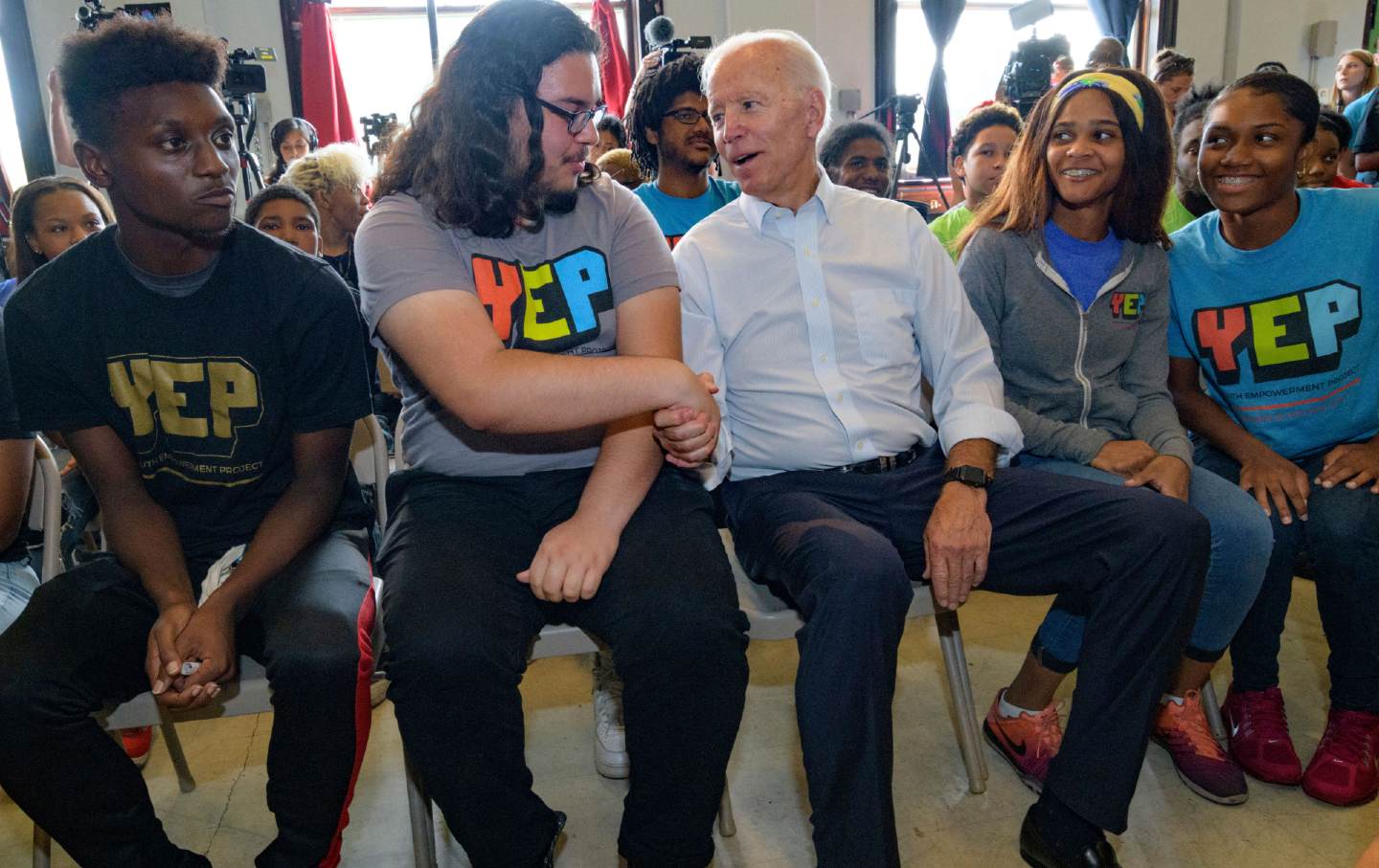 Biden shaking hands with a young voter