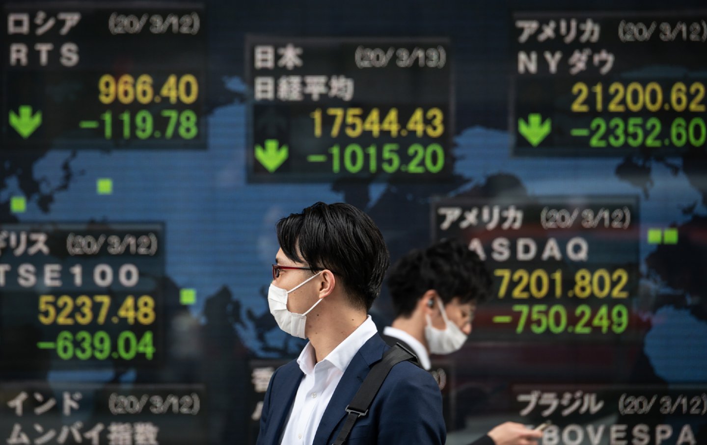 Two people walking past the Tokyo Stock Exchange.