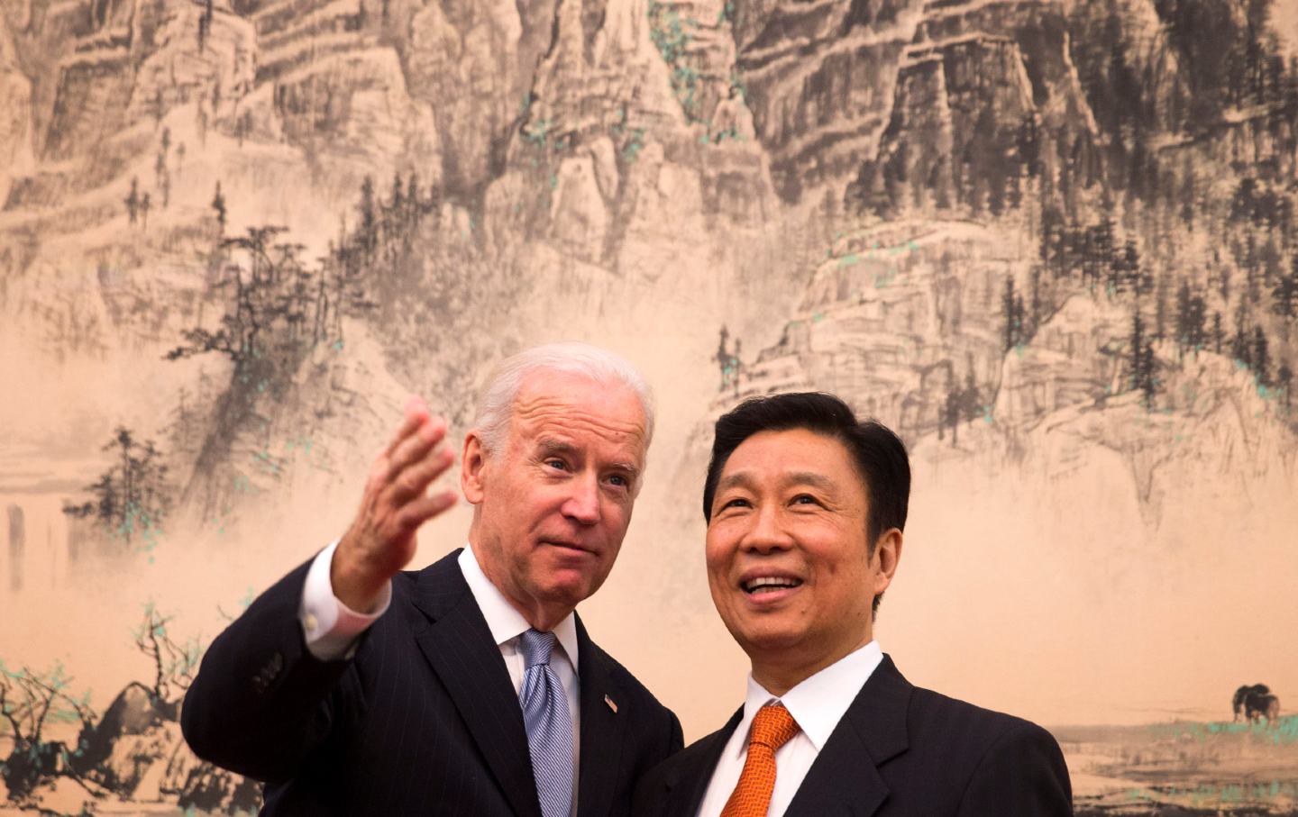 Joe Biden gestures while speaking with a smiling Li Yuanchao