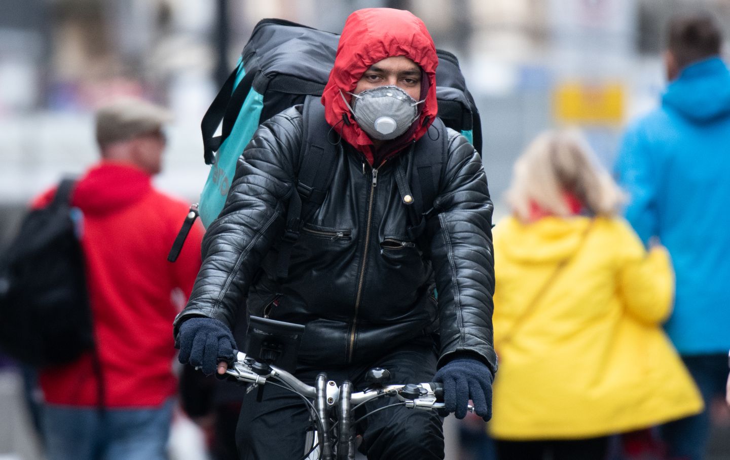 Food service worker biking with a mask