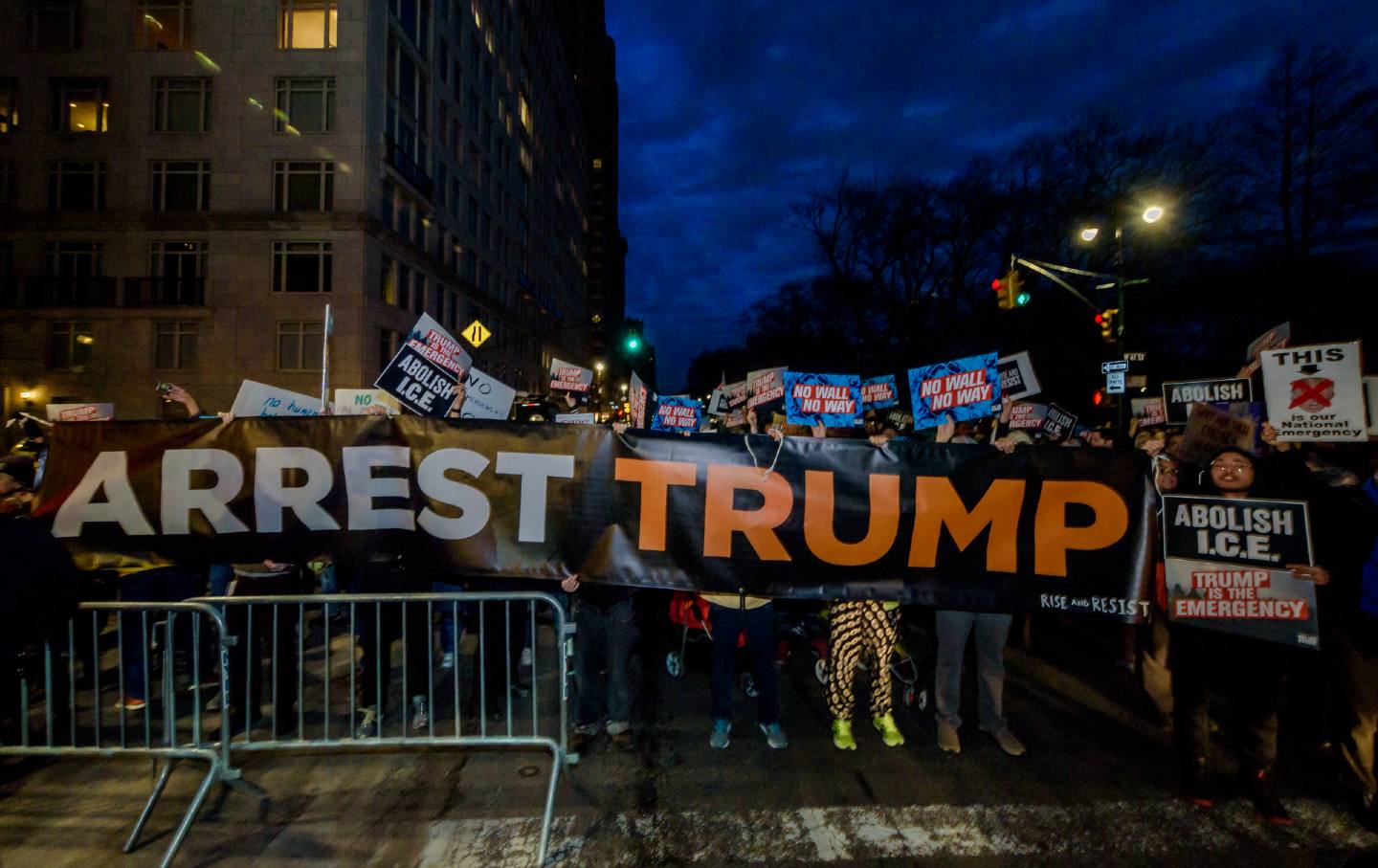 Activists behind a gate read a sign that says 