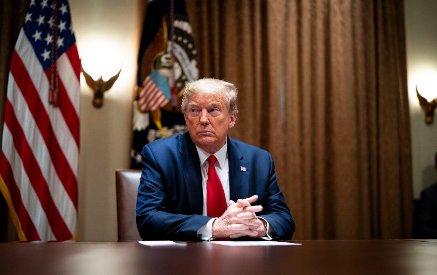 Trump sitting at a table in the White House.