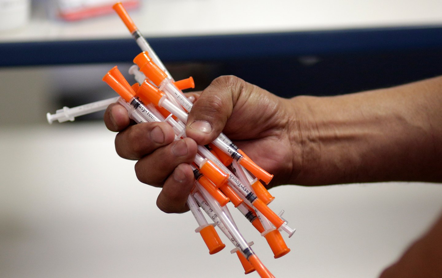 A man grasps a used needles