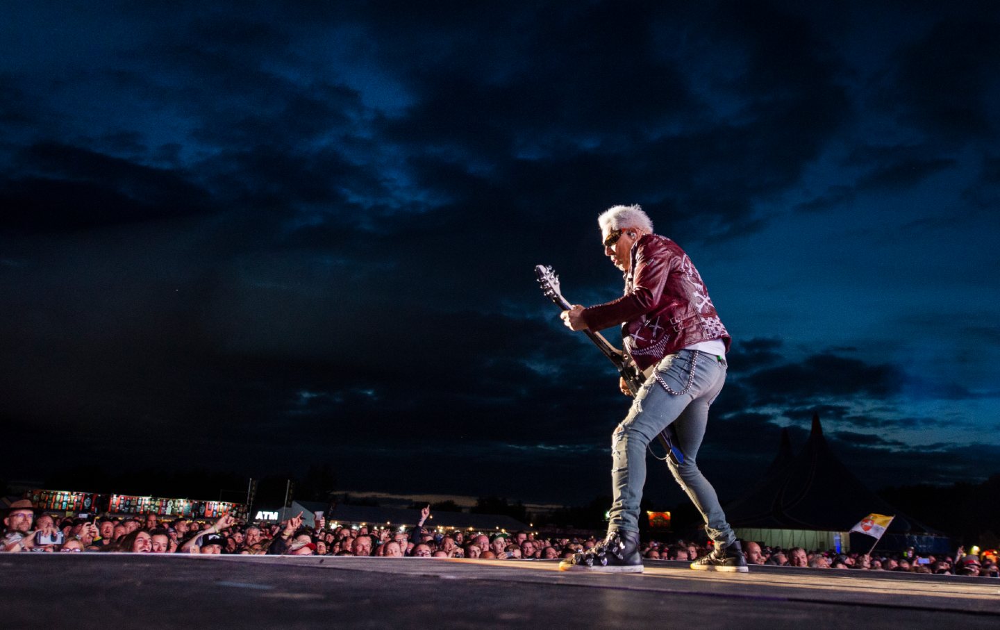 Rudolf Schenker plays guitar on stage to a large crowd