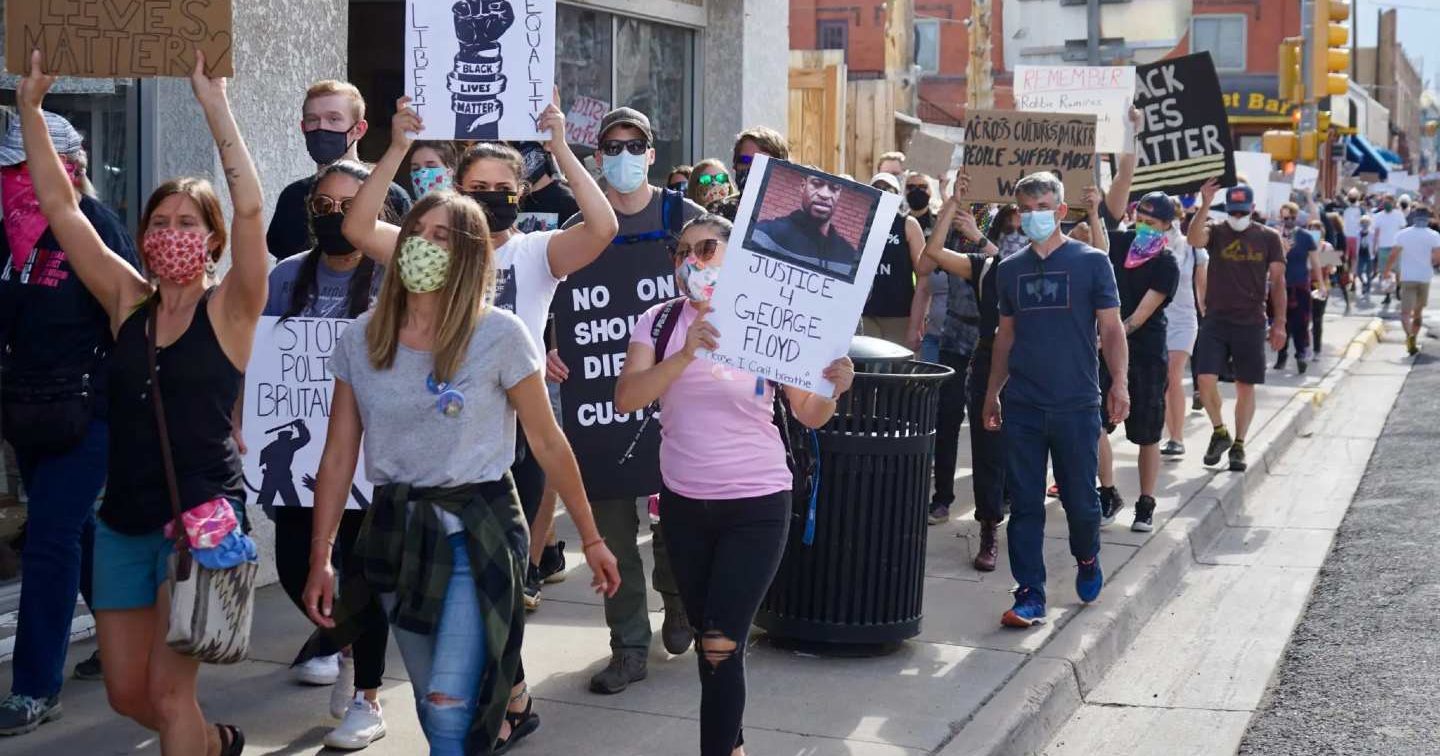 Protesters walk down the street holding Black Lives Matter signs