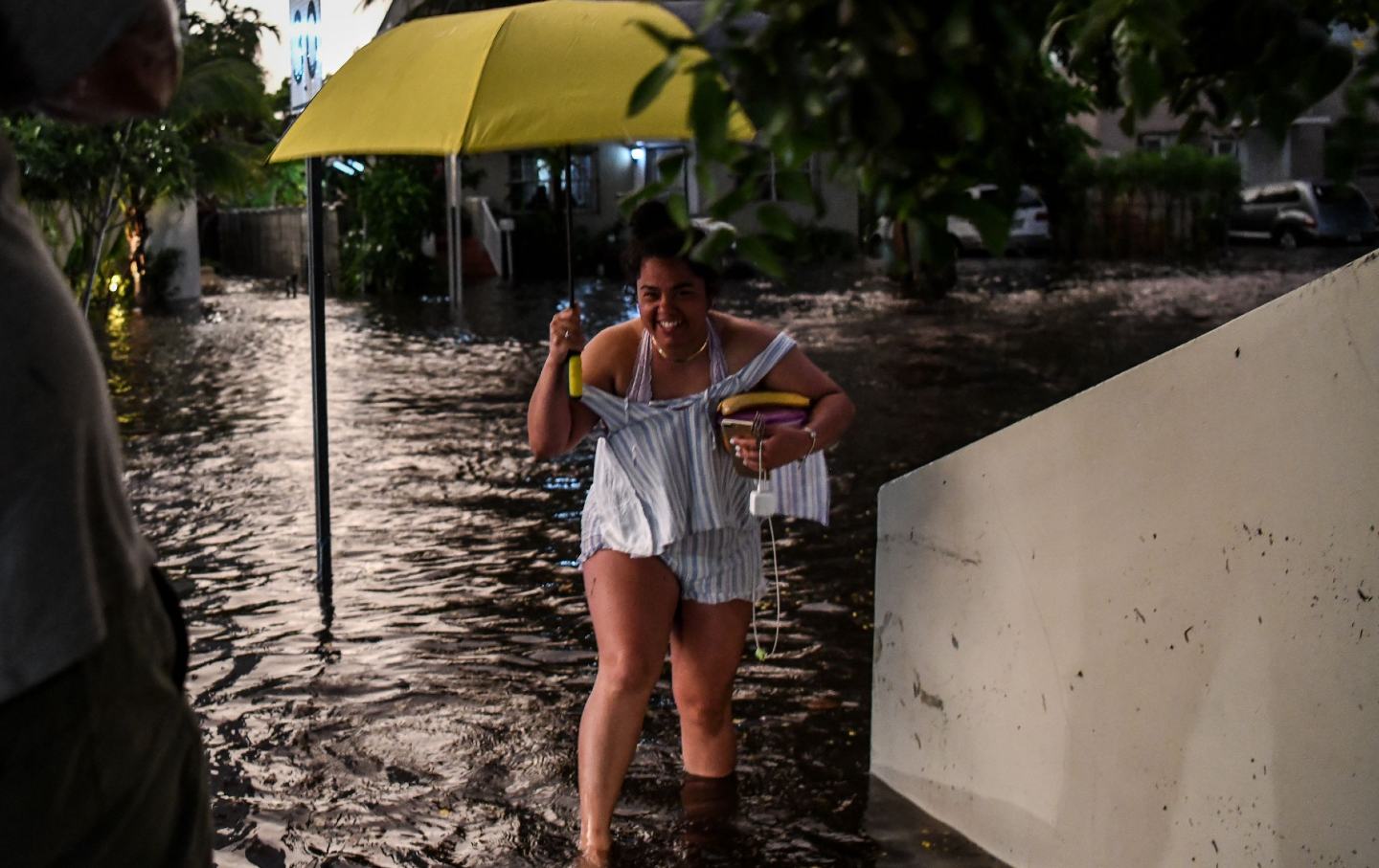 Woman with yellow umbrella walking through Miami