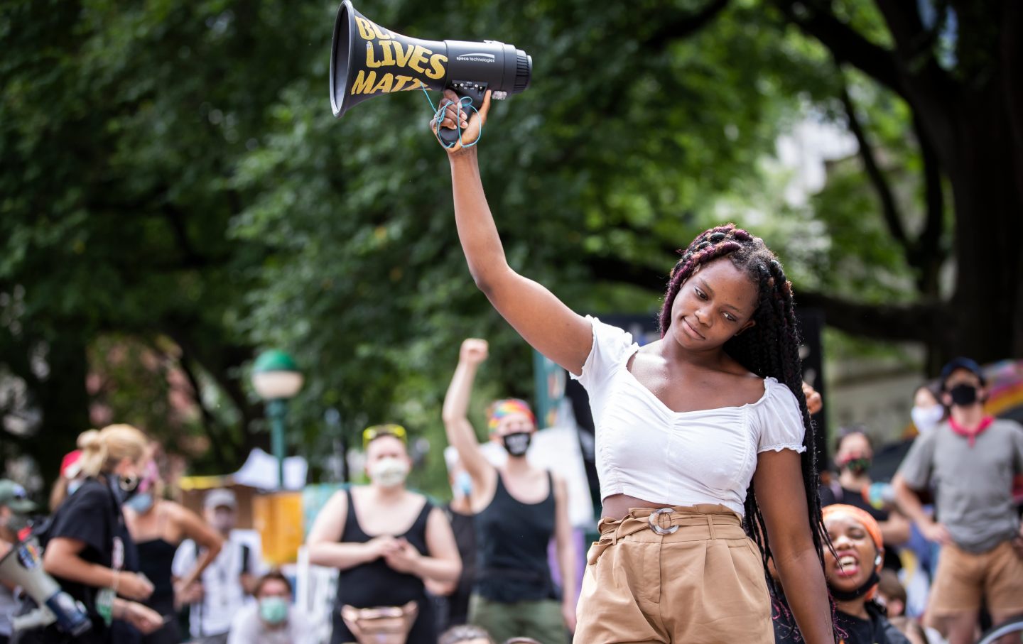 Kiara Williams holds a megaphone in the air that says 