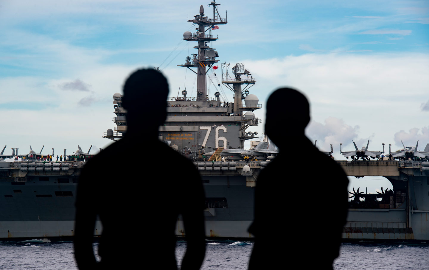 Sailors observe the USS Nimitz and USS Ronald Reagan Carrier Strike Groups steam in formation as the Nimitz Carrier Strike Force.