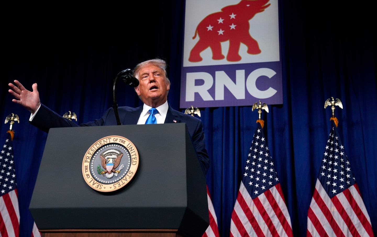 President Trump stands behind lectern on RNC stage.