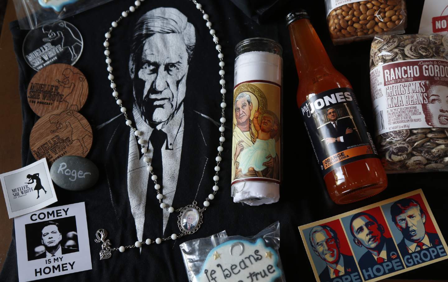 A collection of gift items with Robert Mueller's face on them, including a necklace, a candle, and a poster.