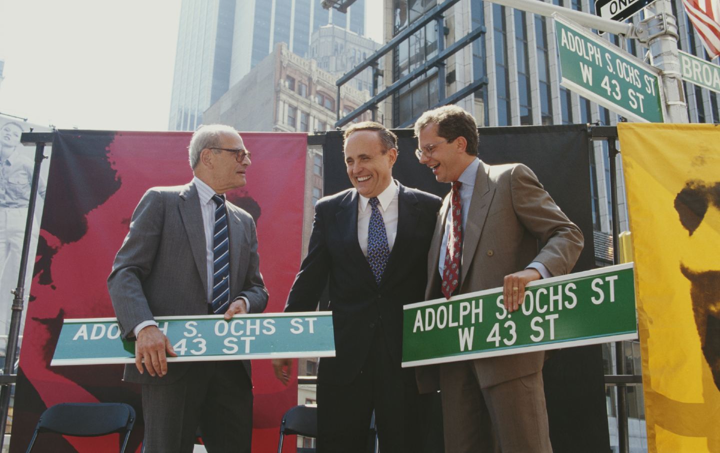 Two men hold street signs reading 