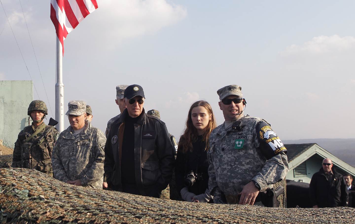 Joe Biden stands with his granddaughter and six soldiers at an Army post.