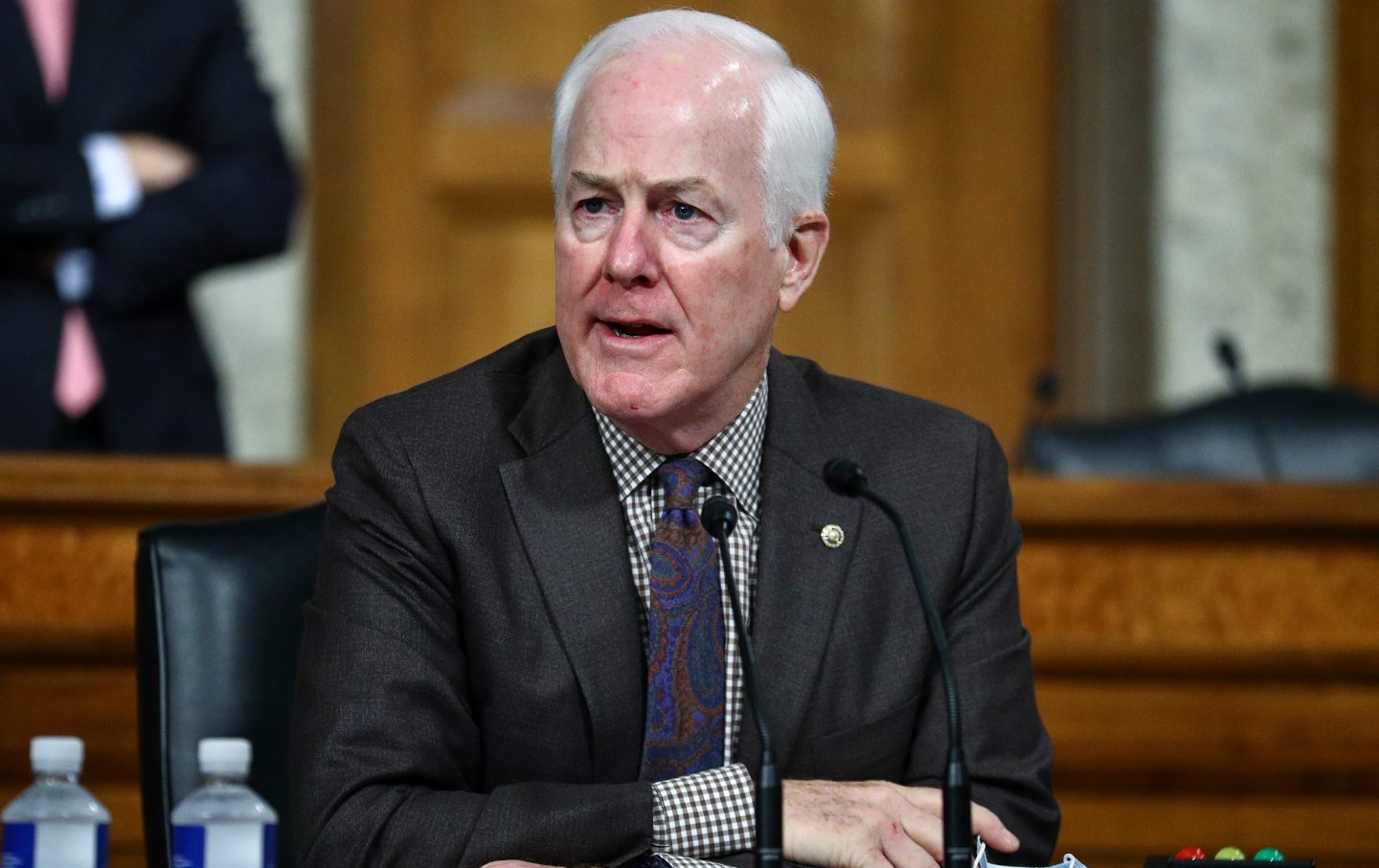 John Cornyn in front of a small microphone.