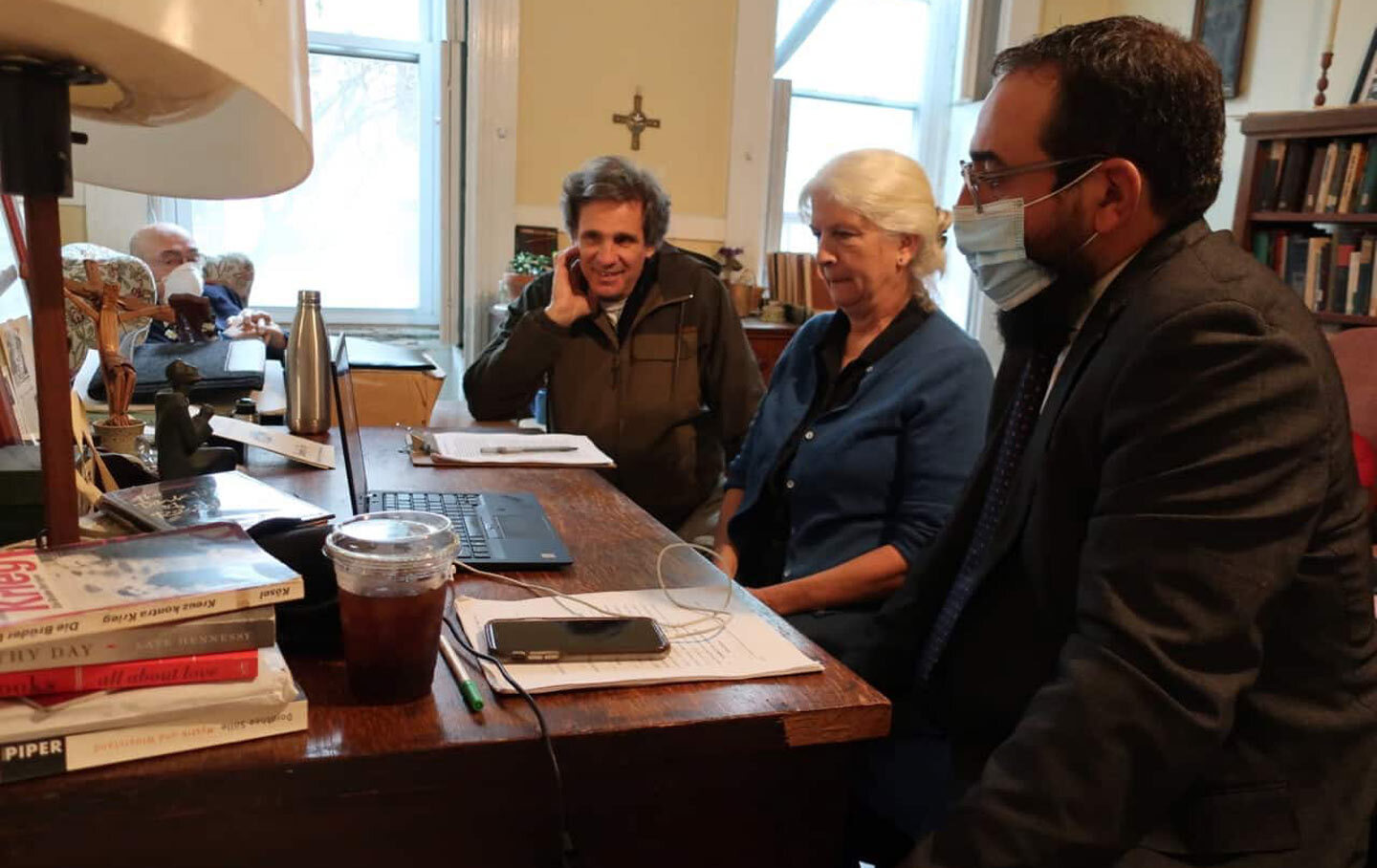 Martha sits at a desk with two other people