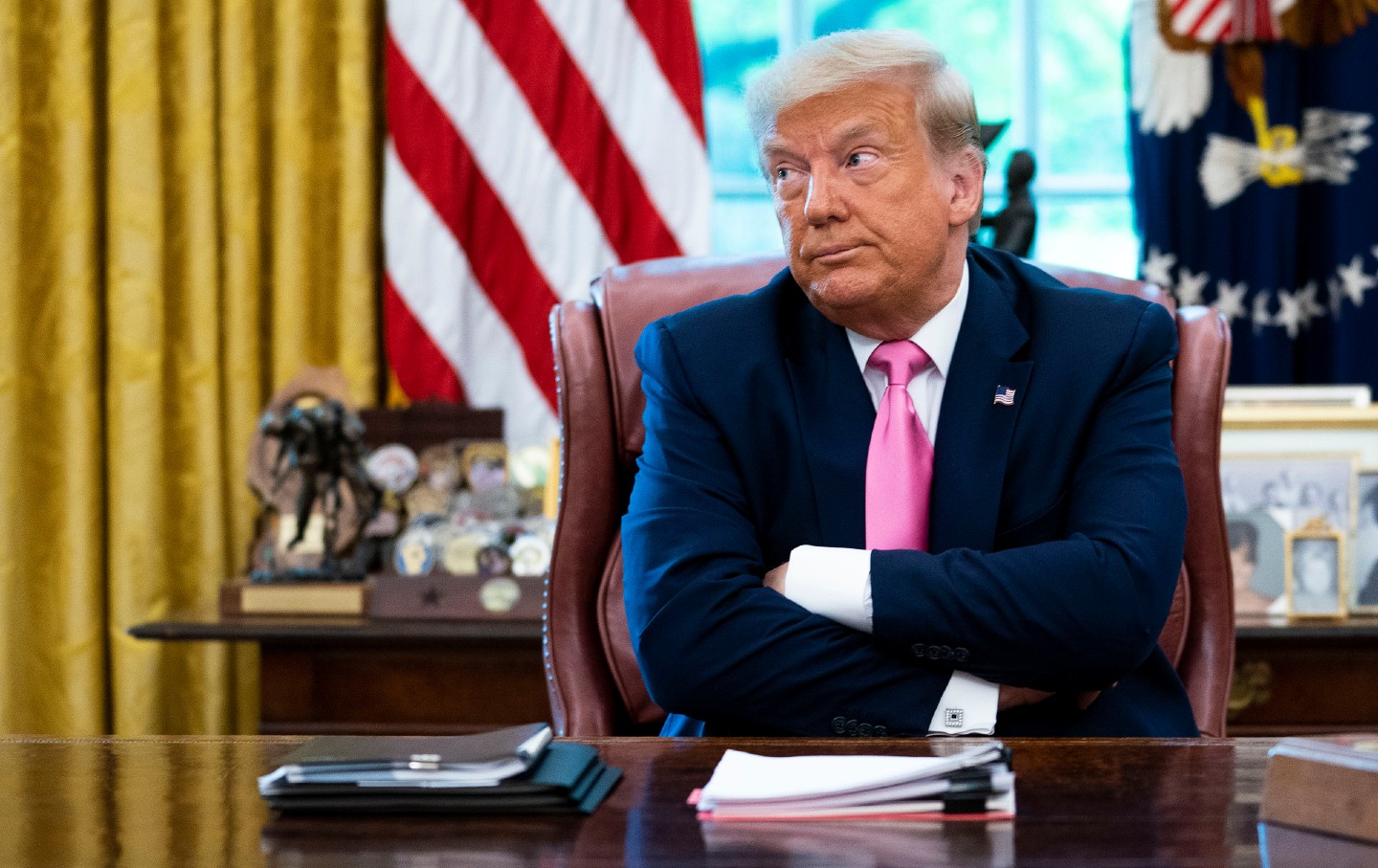 دونالد ترامپ پشت میز خود در دفتر بیضی نشسته و چهره ای پف کرده ایجاد می کند