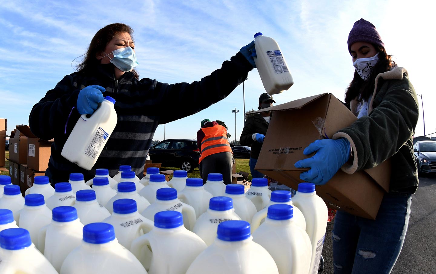 Volunteers fill boxes at a food distribution center.