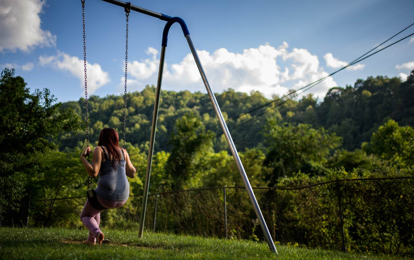 fifteen year old foster girl who just arrived sits on the swing at the Paul Miller Home