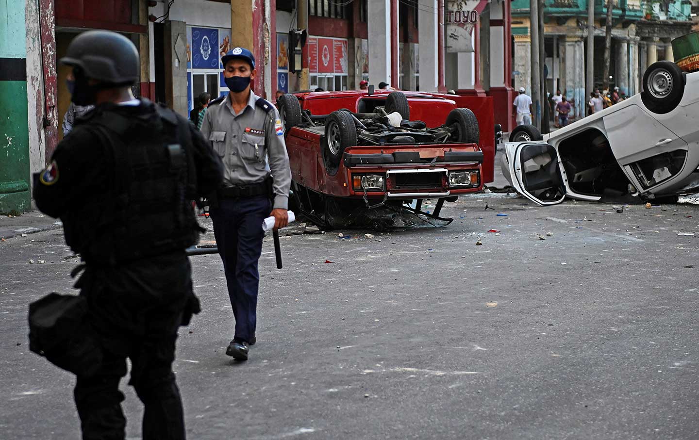 Overturned police cars in the street in the wake of a demonstration against Cuban President Miguel Diaz-Canel in Havana, on July 11, 2021. (Yamil Lage