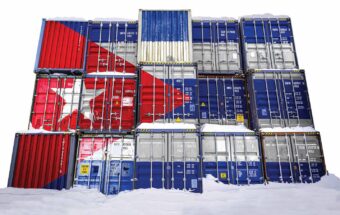 A three by five grid of shipping containers has the Cuban flag painted over it.