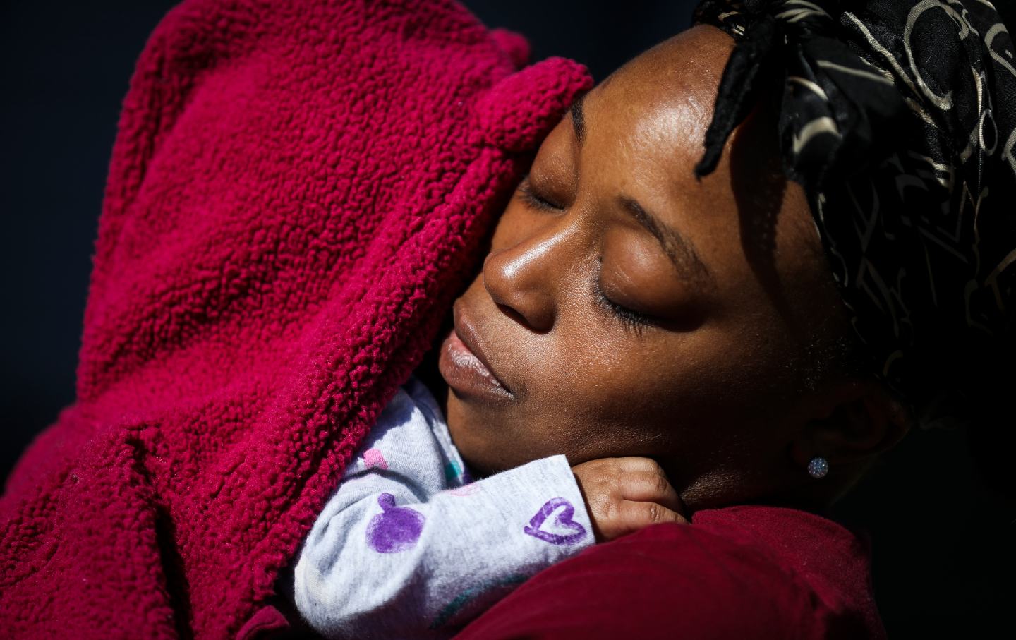 A woman hugs a baby.