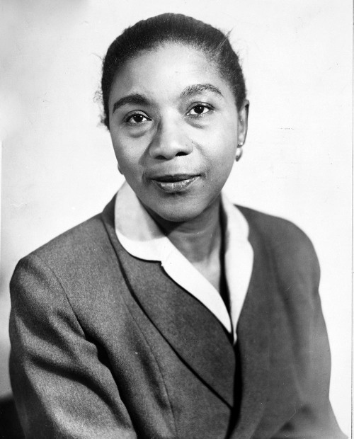 A Black woman in formal dress sits for a portrait