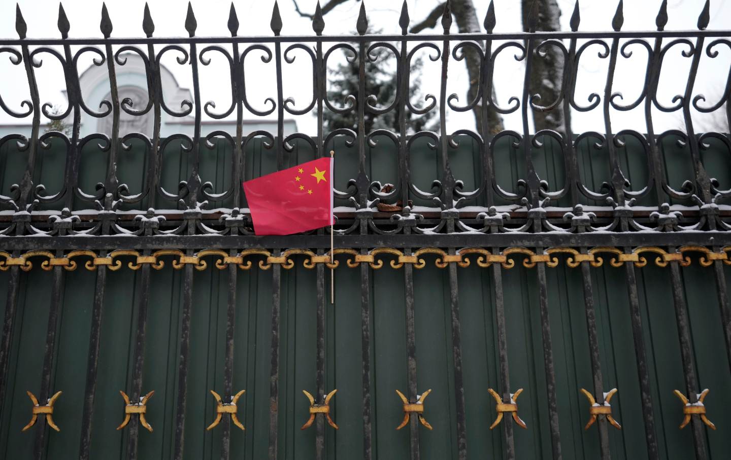 A Chinese flag hangs from a gate