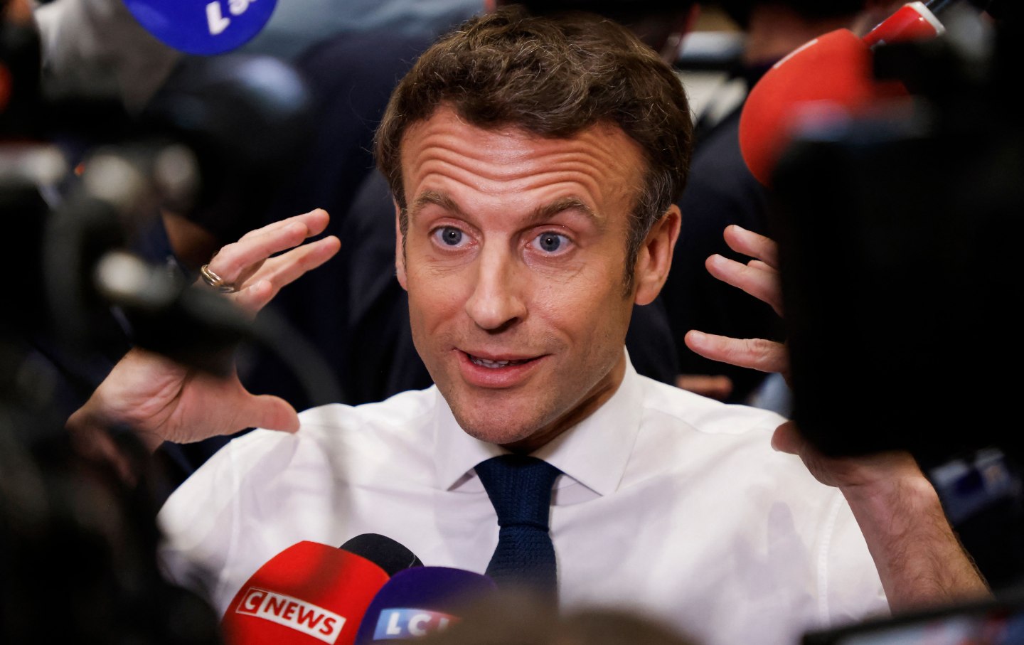 Emmanuel Macron gesticulates while speaking to the press