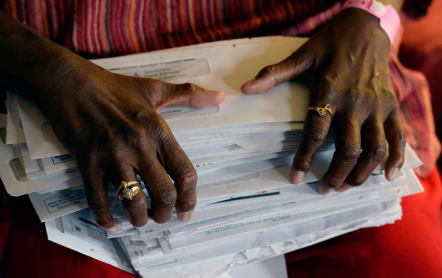 A pair of hands holding a stack of bills.