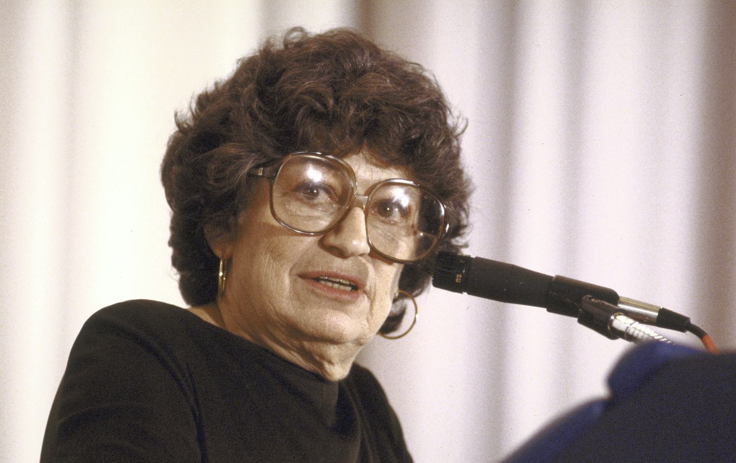 Midge Decter speaking a lectern