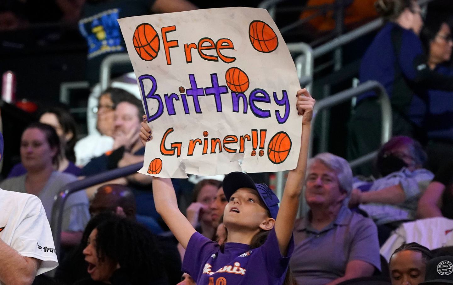 A young girl holds up a sign that reads 