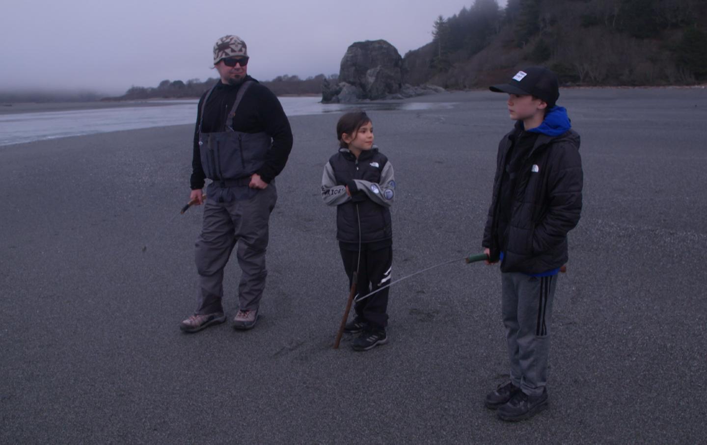 Barry McCovey Jr. with two of his children on a beach.