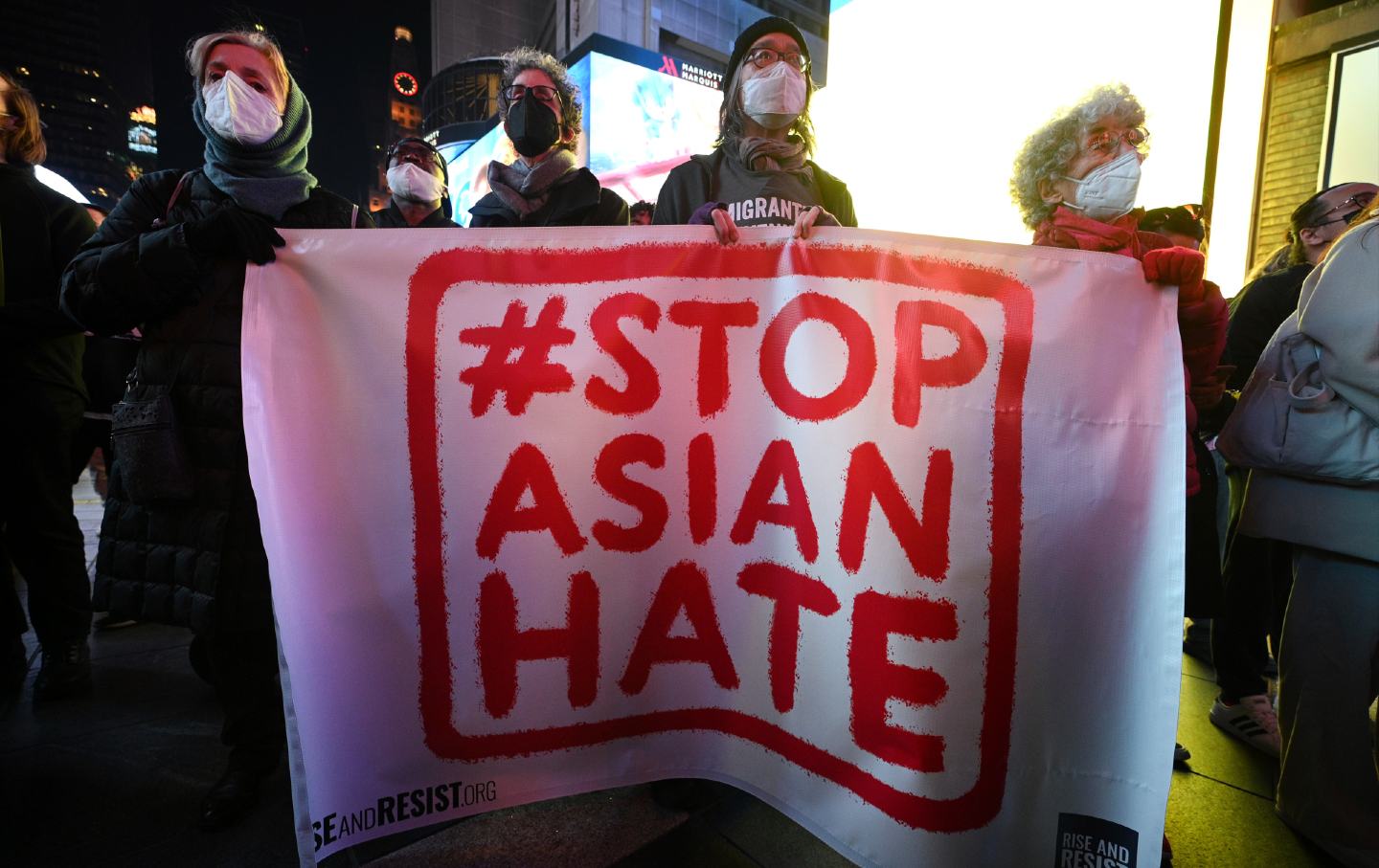 Protesters attend a Justice for Asian Women rally in Times Square. They are holding a #StopAsianHate sign.