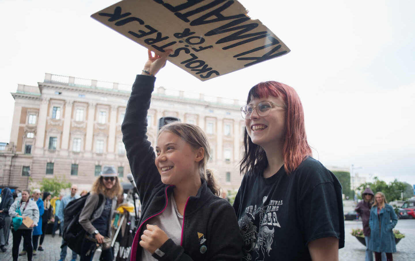 Greta Thunberg, 19, takes cover from the rain