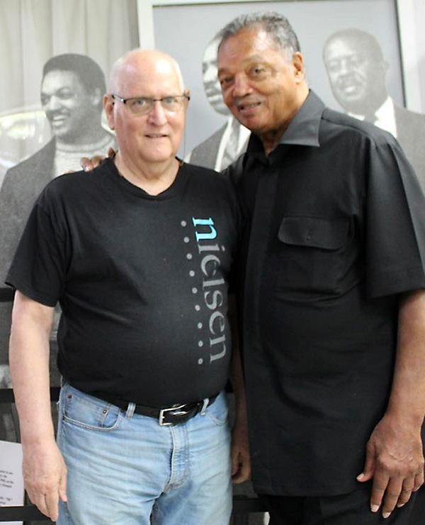 Frank Watkins and Jesse Jackson stand next to each other in black shirts.