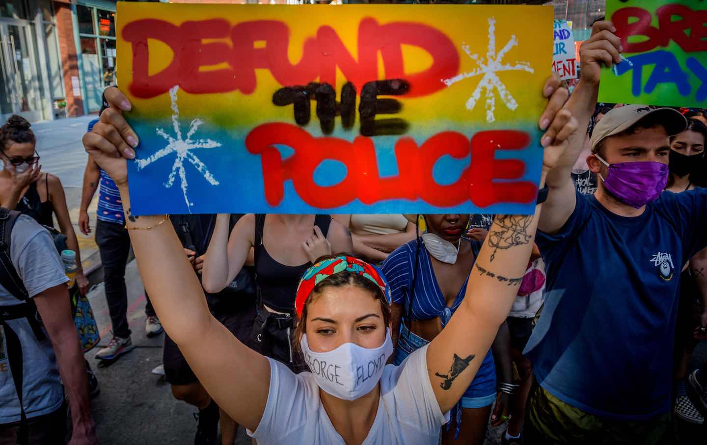 A participant holding a “Defund the Police” sign at a protest