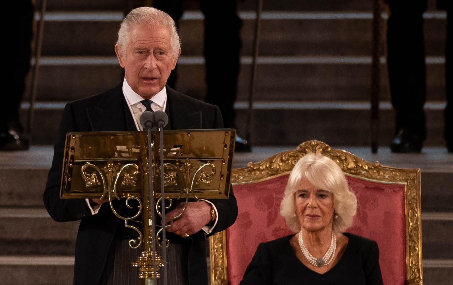 King Charles III speaks as now-Queen Camilla sits beside him at Westminster Hall.